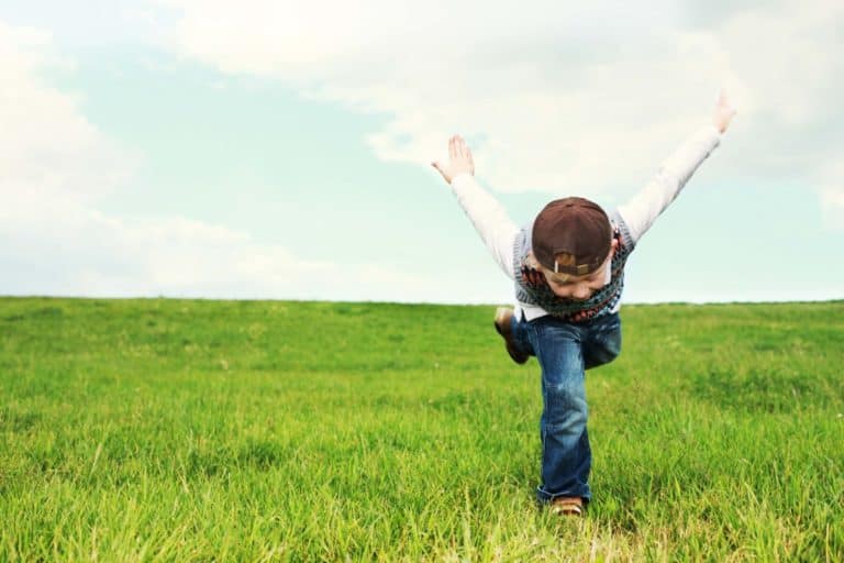 An energetic child running in a field.